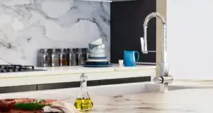 A white quartz stone countertop in a large kitchen with an island and backsplash in the same matching granite.