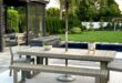 A large backyard with a pergola, table and chairs with an umbrella, a rectangular pool, and a concrete patio.